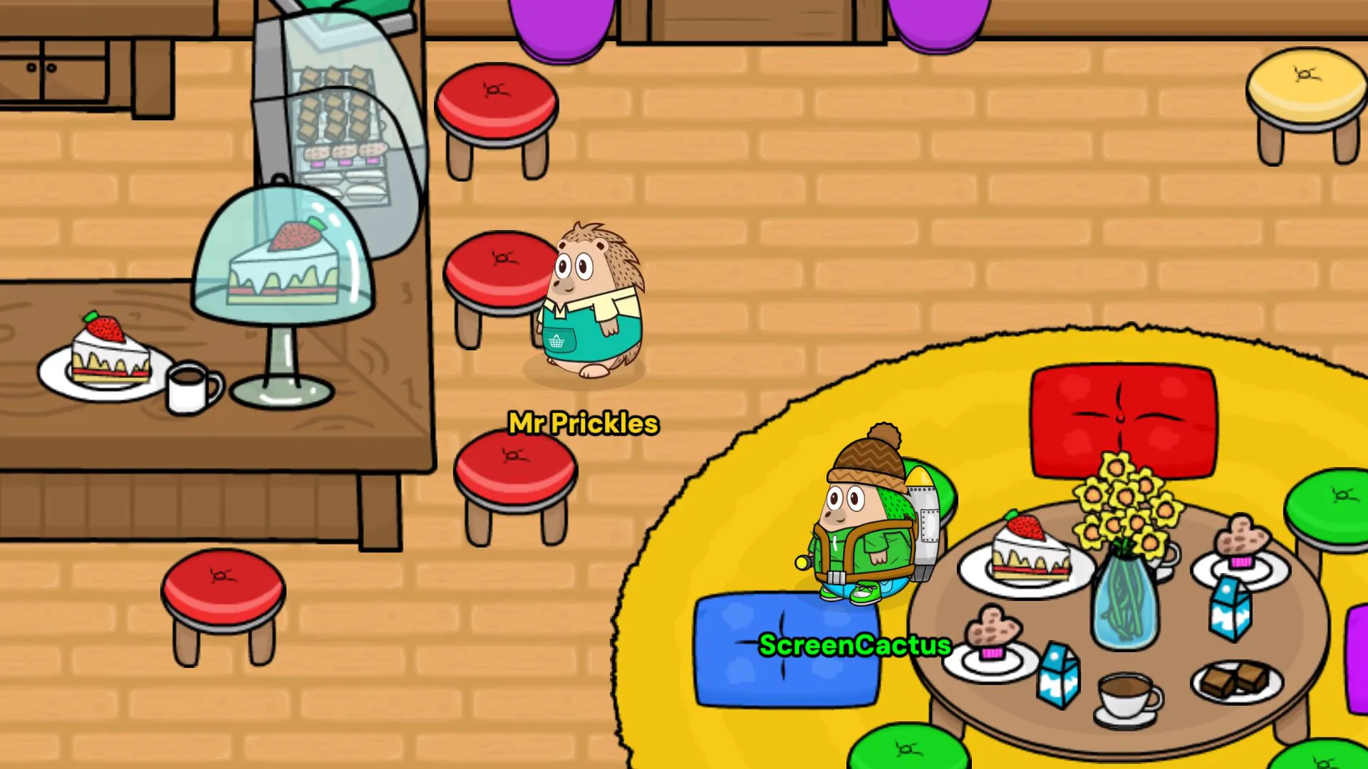 ScreenCactus at a table of cakes and cocoa on the yellow rug in the Cafe while Mr Prickles walks past the counter